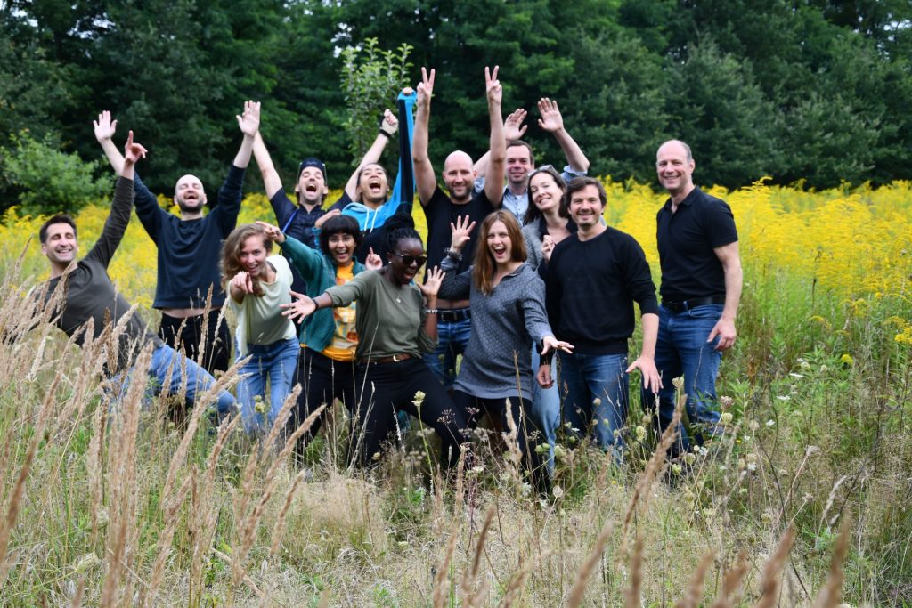 Coworkers smiling and cheering in a forest