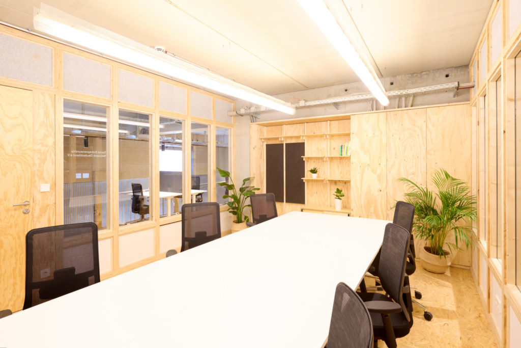 A meeting room with a long table and ergonomic chairs