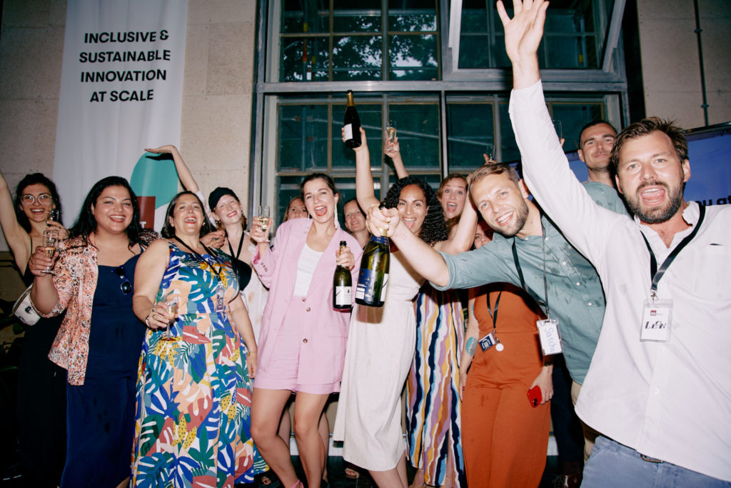 Impact Hub Berlin Team Mitglieder feiern mit Champagner