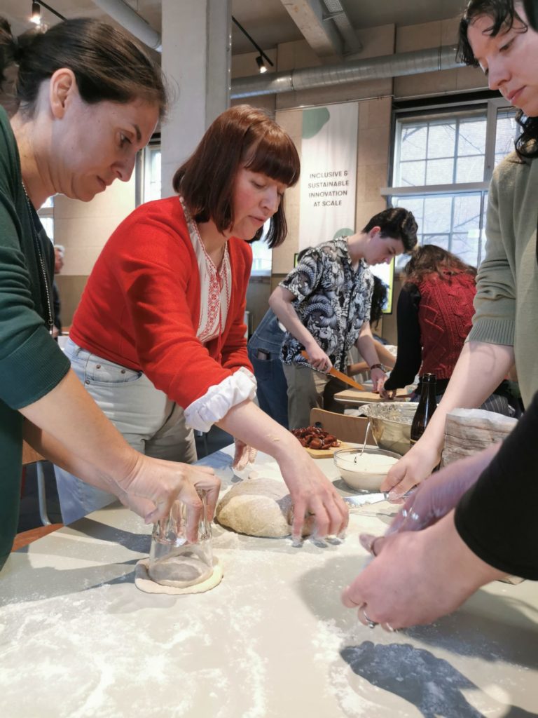 A woman showing others how to knead dough
