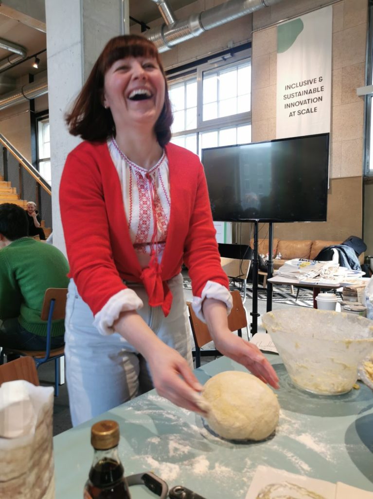 A woman kneading dough and laughin