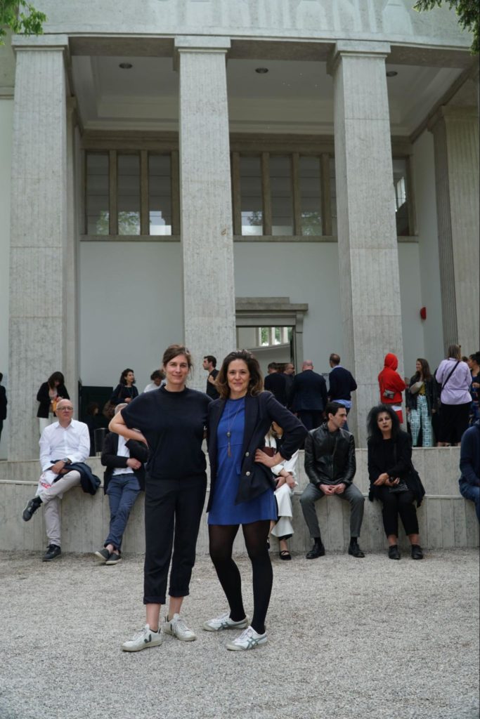 The two architects of the CRCLR House standing in front of the entrance of the German pavilion at the Biennale 2023
