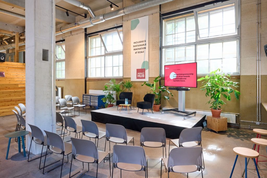 An empty stage and chairs prepared for an event at the café area of Impact Hub Berlin
